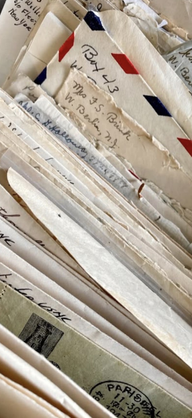 A stack of vintage handwritten envelopes and airmail letters